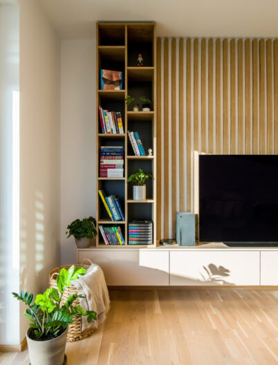 Detailná časť knižnice s televíznou stenou a dekoráciami v modernom interiéri, realizácia od INTTERIO Bratislava